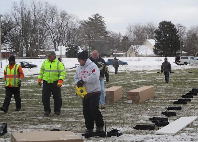 Volunteers Alan Dunski (from left), Pat Dunn, Bruce Nopenz and Roger Johnson get ready to measure and lay out boards for the Silver Lake ice skating rink in Schmalfeldt Park on Dec. 31. The rick should be open, weather permitting, about Jan. 12. (Photo by Gail Peckler-Dziki).