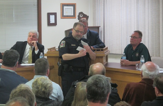 Wheatland Town Constable Robert Santelli Jr. reads off a series of questions submitted by those in attendance at a public information on release of two sex offenders. Kenosha County Deputy District Attorney Michael Graveley (left) and Sheriff David Beth (right) gave statements earlier in the meeting (Jason Arndt/The Report).