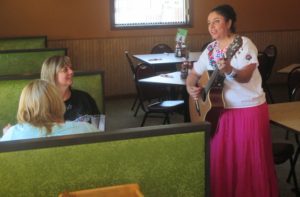Singer Blanca Tapia serenades Shelly Ericksen and Christine Sura at the June 17 grand opening of El Sinaloense in the Village of Twin Lakes.  (Jason Arndt/The Report).