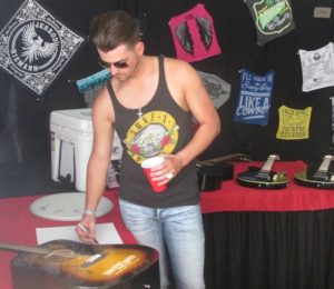 Chase Bryant signs autographs in the Meet and Greet tent at the Country Thunder Music Festival grounds Thursday. Bryant, who fielded an interview with the Report, had his show cancelled due to weather (Jason Arndt/The Report).