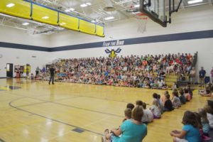 BMX rider Matt Wilhelm addresses more than 500 Wheatland Center School students at an assembly Sept. 8, when they also unveiled a Buddy Bench, in an effort to tackle bullying (Photo Submitted/The Report).